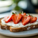 Toast topped with light cream cheese and fresh strawberries